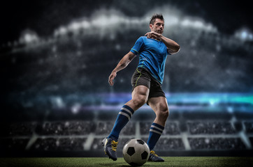 Fototapeta na wymiar Football player with ball on field of stadium