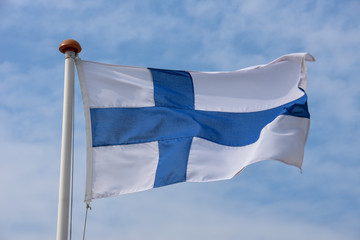 Finnish flag waving against blue sky