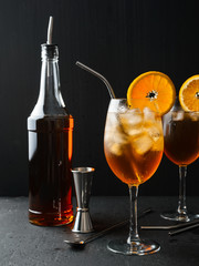 Alcoholic cocktail Aperol Spritz in a wine glass covered with water drops, slice of orange ,ice cubes and metal straw