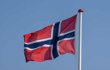 Norwegian flag waving against blue sky