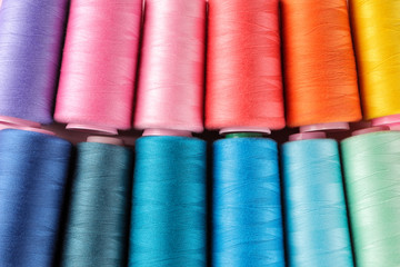 Accessories for sewing and needlework. Many multi-colored spools of thread. Bobbins with colored thread