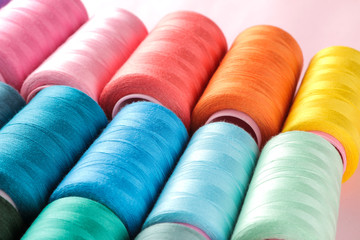 Accessories for sewing and needlework. Many multi-colored spools of thread. Bobbins with colored thread