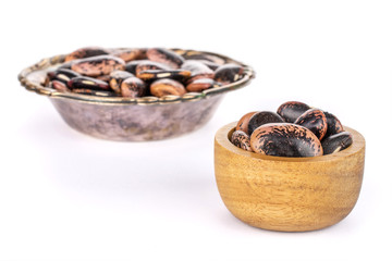 Lot of whole stained purple bean in tiny wooden bowl in metal bowl isolated on white background