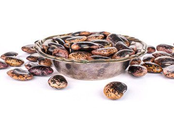 Lot of whole stained purple bean in metal bowl isolated on white background