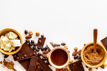 Chocolate with nuts and its ingredients on white background top view copyspace