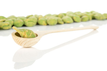 Lot of whole spicy green wasabi peanut in a wooden spoon isolated on white background
