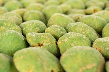 Lot of whole spicy green wasabi peanut in closeup isolated on white background