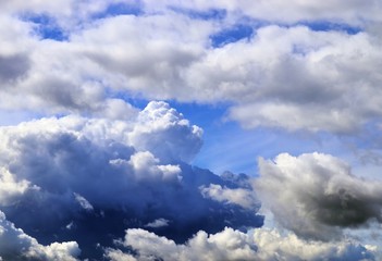 Dramatic and fluffy white clouds on a deep blue summer sky 