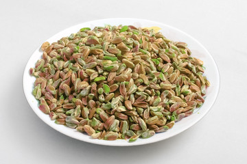 pistachio nuts in plate on white background