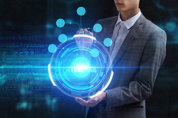 The concept of business, technology, the Internet and the network. A young entrepreneur working on a virtual screen of the future and sees the inscription: Video marketing