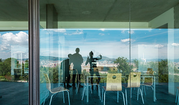 Barcelona mirroring in a window with three persons