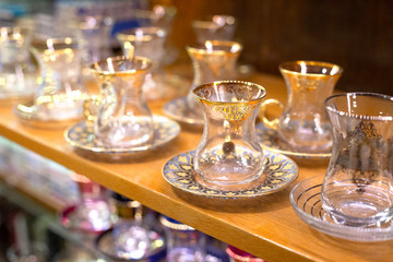 Traditional famous turkish tea cup with plate on the shelf in the shop. One of the most popular souvenir from Istanbul, Turkey.  