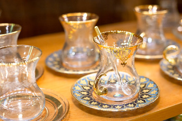 Traditional famous turkish tea cup with plate on the shelf in the shop. One of the most popular souvenir from Istanbul, Turkey.  