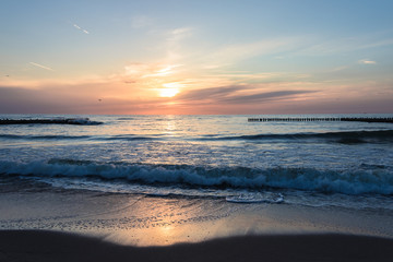 Water landscape with sunset over the waving sea.