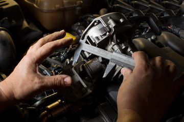 Fototapeta na wymiar Hands measure the piston of a car engine using a ruler