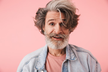 Portrait closeup of pleased mature man 70s with gray beard and messy hair smiling at camera