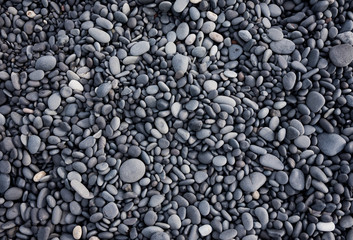 Fototapeta na wymiar Gray pebbles as a background in the Iceland sea shore. Abstract composition. Design - image