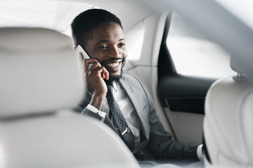 Successful businessman talking on phone in car