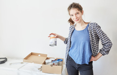 Frau als Heimwerkerin mit einer Farbdose