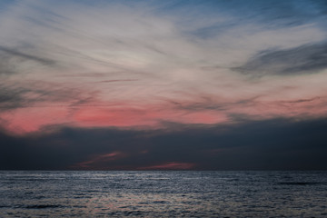 Water landscape with dramatic sky at the sunset over the waving sea.