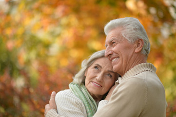 Fototapeta premium Happy senior couple in autumn park hugging
