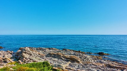 Fototapeta na wymiar The sea horizon and rocky ligurian coast