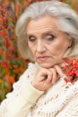 Portrait of sad senior woman in autumn park