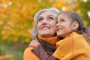 Grandmother with her granddaughter in the autumn park