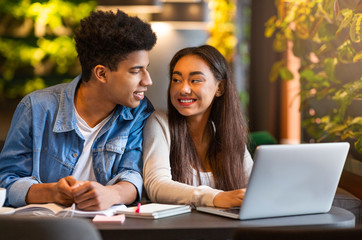 Studying students looking at each other and smiling