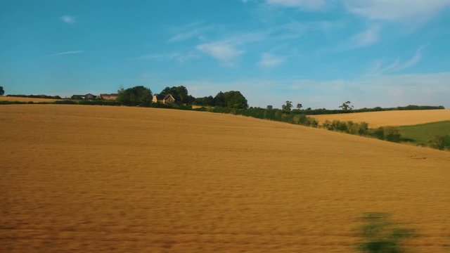 Passenger view of amazing croplands and rolling hills in the Cotswolds in England, UK, an Area of Outstanding Natural Beauty with 787 square miles, the second largest protected landscape in England