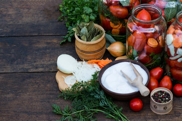 Fermented tomatoes in big jars on the table cut carrot onion and spice outside copy space