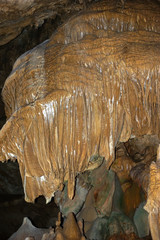 Secluded place. The dark depths of the earth. Caves. Stalactites and stalagmites inside the cave. Large stalactite resembling a head.