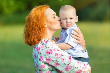 Red-haired mother with son on hands