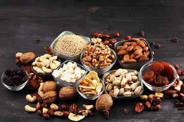 Composition with dried fruits and assorted healthy nuts on rustic background
