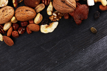 Composition with dried fruits and assorted healthy nuts on rustic background