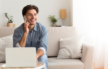 Young Entrepreneur Talking On Phone Sitting At Laptop Indoor