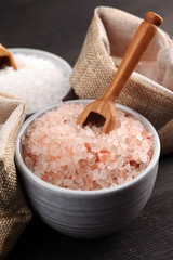 Sea salt and himalayan in bowl. Crystals of salt on dark background