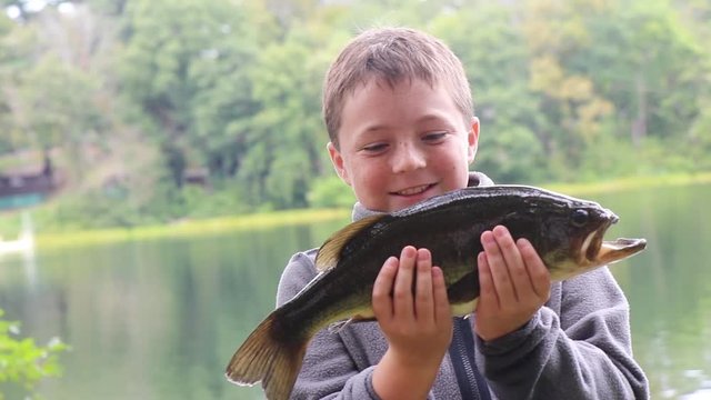 Child with big bass fish. The big catch. 