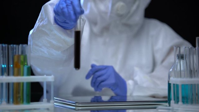 Chemical laboratory researcher examining test tube with naphtha, fuel quality