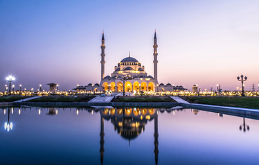 Fototapeta na wymiar Beautiful Mosque in the world Largest Mosque in Sharjah traditional Islamic architecture new tourist attraction in Middle East evening shot of New Sharjah Mosque 