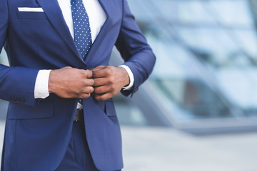 African American Businessman Buttoning Up Jacket In City, Cropped