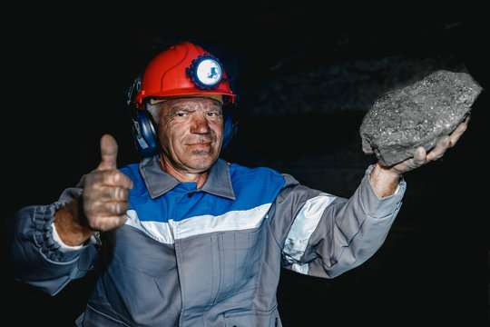 Portrait miner coal man in helmet with lantern in underground mine. Concept industrial engineer