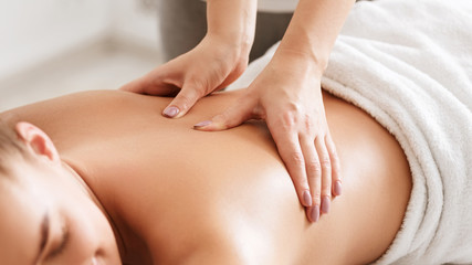 Fototapeta na wymiar Body care. Young girl having massage, relaxing in spa salon