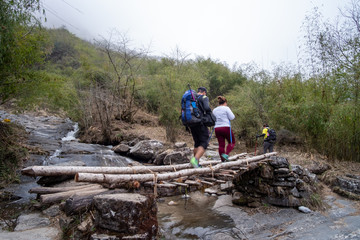 Obraz premium Trekker on the bridge between way to Annapurna base camp, Nepal.