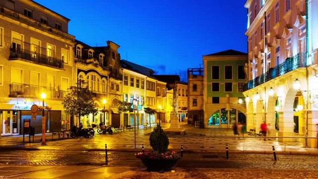 Aveiro, Portugal. View of city center at night with illuminated buildings and car trails. Time-lapse at night with dark blue sky, zoom in