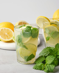refreshing drink lemonade with lemons, mint leaves, lime in a glass