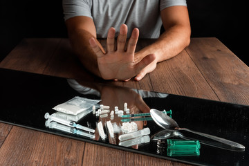 A man with a stop gesture refuses drugs, the fight against drug addiction. Social problem, drug...