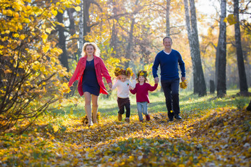 Mom dad children walk in the autumn park. Family for a walk in the forest