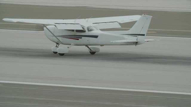 Small generic private propeller airplane preparing for landing, no tail or identification number. 60 FPS Slow Motion, 4K RAW graded footage