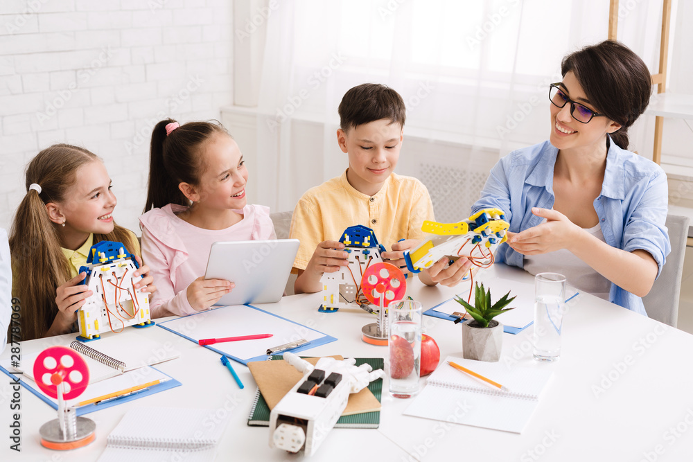 Poster Children creating robots with teacher in classroom at stem lesson